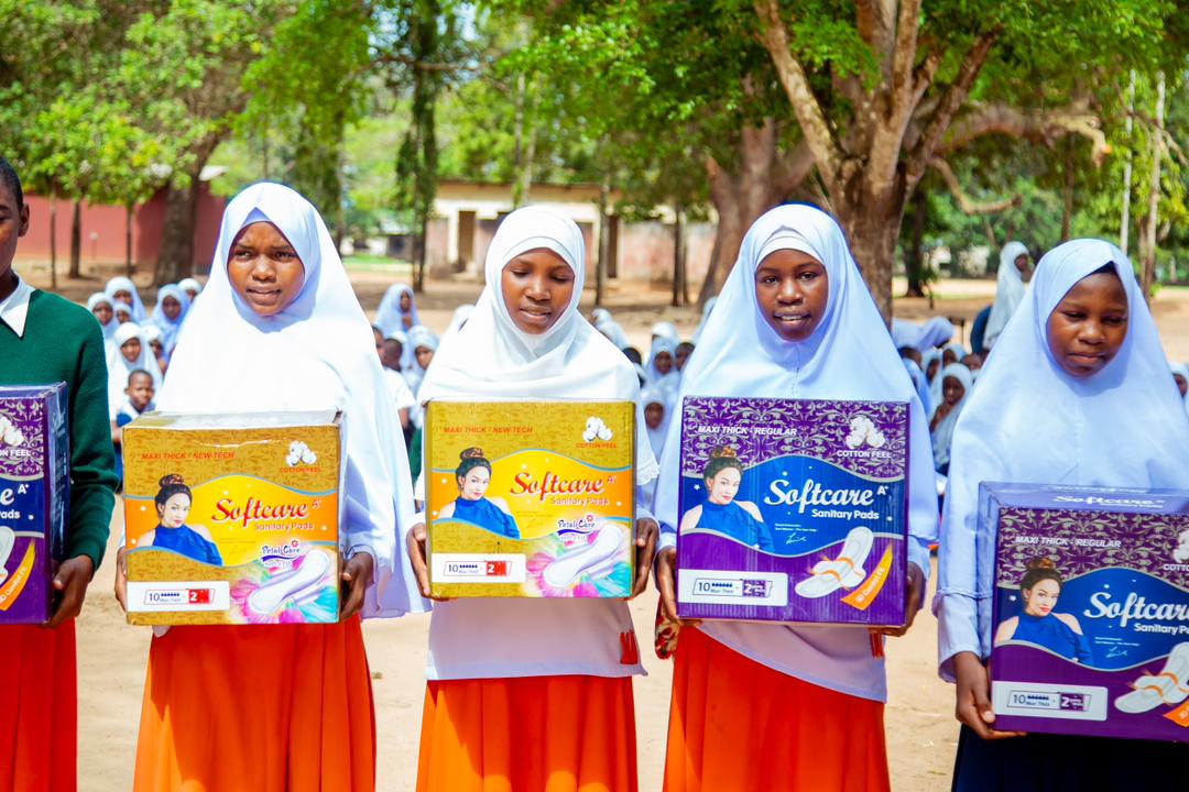Schoolgirls holding sanitary care packages received during a foundation visit